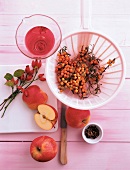 Basket of rosehips, sea buckthorn, apples and cloves on table