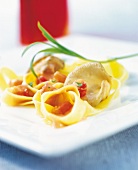 Close-up of tagliatelle pasta with tomatoes and oyster mushrooms on plate