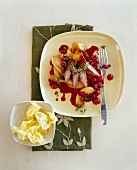 Lamb fillet and apples drizzled with cherry sauce on plate