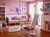 Living room in pink and white with rocking chair, sofa, cabinets and white curtain