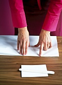 Woman folding paper while making leporello album