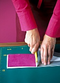 Woman cutting extra paper with cutting knife while making leporello album
