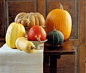 Still life with pumpkins, butternut and other fruits on wooden table