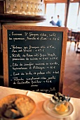 Eine Schiefertafel zeigt Gerichte und Preise eines Restaurants
