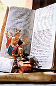 Abrechnungsbuch in alter Schrift mit barocker Heiligenfigur