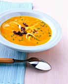 Pumpkin soup with smoked pork in bowl