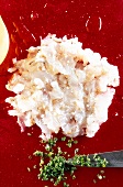 Peeled and deveined raw prawns cut into small pieces with knife, overhead view
