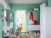 Hallway with colourful tiles, white wardrobe and telephone table