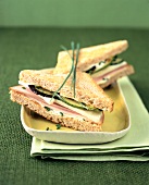 Whole grain bread sandwich with turkey and vegetable on serving dish