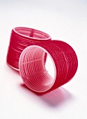 Close-up of red velcro hair curlers on white background