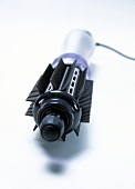 Close-up of round brush curling iron and blow dryer on white background