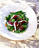 Marinated bean salad with duck breast on plate