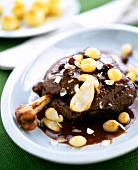 Sauerbraten deer garnished with peanuts and sauce on plate