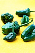 Close-up of padron peppers on yellow background