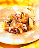 Close -up of Sobrassada with potato noodles, chipirones and mussels on plate