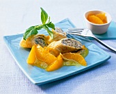 Pancakes with honey, mint cream and oranges on plate