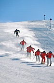 Fünf Skifahrer bei der Abfahrt am Arlberg