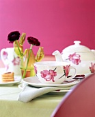 Close-up of teacup and teapot with rose motif