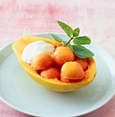 Papaya with yogurt and mint leaves in papaya