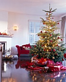 geschmückter Weihnachtsbaum im Wohn- zimmer mit Geschenken