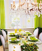 Elegant festive table with green decorations and chandelier