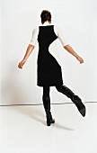 Frau in schwarzem Etui-Kleid 60er-Jahre-Stil
