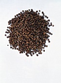 Grains of paradise peppercorn on white background
