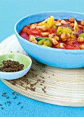 Close-up of chickpeas with stew and cumin in bowl