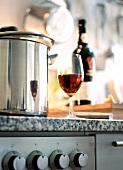 Close-up of cooking pot and wine glass on stove pot