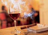 Rotwein im Rotweinglas mit Zigarre im Aschenbecher