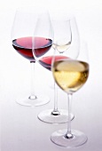 Close-up of red wine, white wine and champagne in glasses on white background