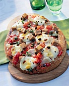 Flatbread pizza with tuna toppings on wooden board