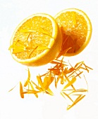 Close-up of two halves oranges and flower petals on white background