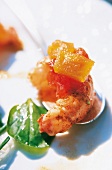 Close-up of shrimp with diced vegetables and basil leaf