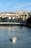 View of ferry boat on the Saone River and cityscape of Lyon, France