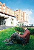 Statue lesender Mann vor Eingang Hotel Four Seasons