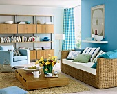 Blue painted living room with wooden flooring, rattan wicker sofa and bookshelf