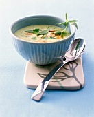 Lovage and potato soup with almonds in bowl