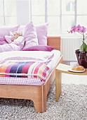 Peaceful woman sleeping on wooden bed with pink bedding, pillows and bedspread