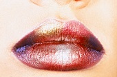 Close-up of woman's lips wearing multi-coloured shiny lipstick