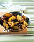 Potato, black olive and dried tomatoes in cooking pan