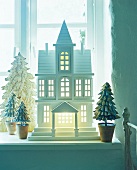 Holzhausmodel mit Tannenbäumen, weihnachtliche Dekoration