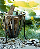 Pot of iron with wood logs on pebbles stones