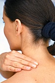 Woman performing acupressure for shoulder and neck pain