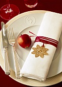 Napkin wrapped with red ribbon and apple on plate