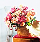 Strauß mit Rosen in einem Korb im Zimmer, Freilandrosen