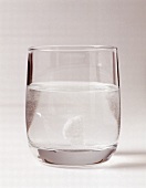 Tablette löst sich in einem Glas Wasser auf