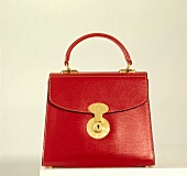 Close-up of red leather handbag on against white background