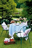 Dining table and wicker basket with food in garden