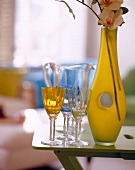 gelbe Blumenvase mit Loch, drei Gläserundeine Karaffe